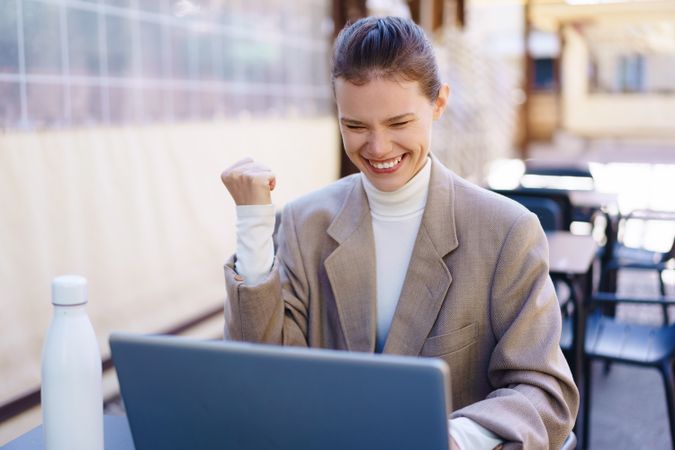 Joyful Businesswoman Celebrating Her Success at an Outdoor Workspace with Enthusiasm