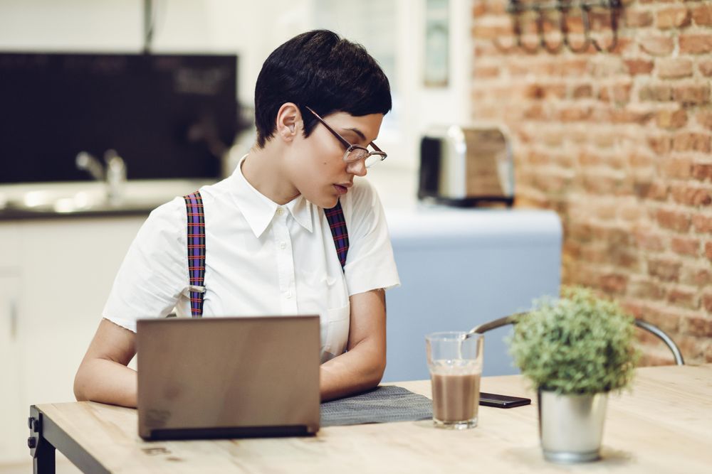 Woman in loft apartment working on computer at table