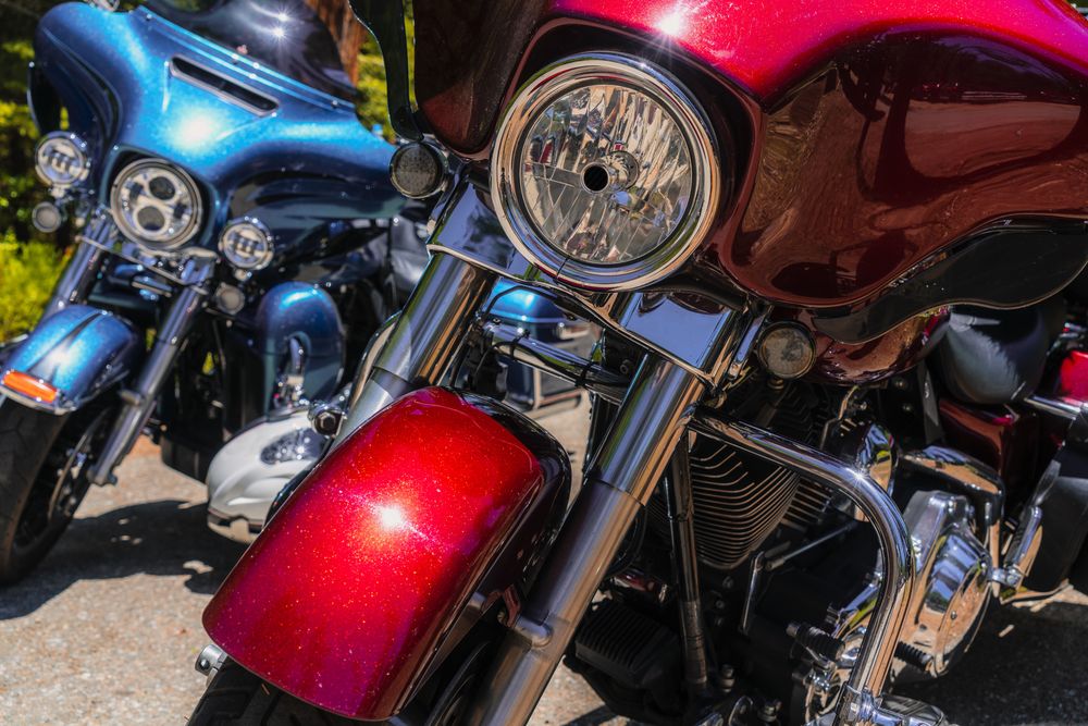 Red and blue motorcycles in street in sun day