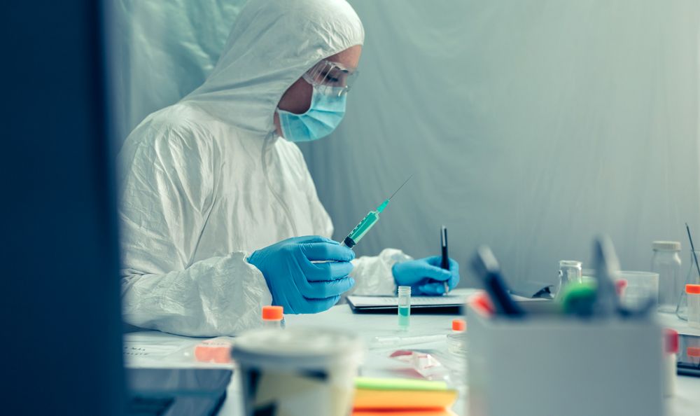 Scientist with protection suit investigating a vaccine in the laboratory