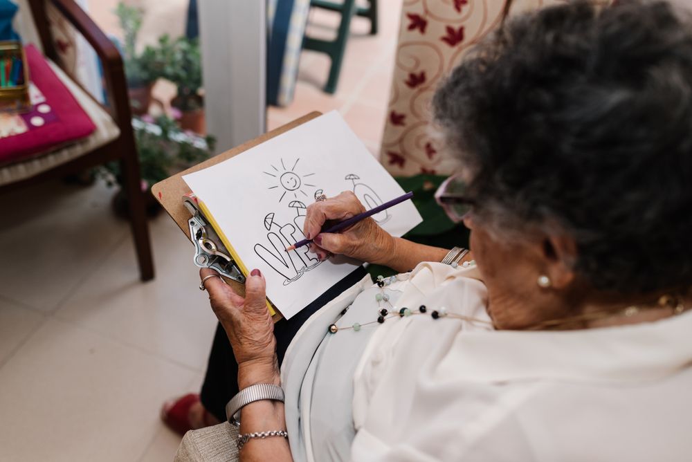 mature female drawing on paper in apartment