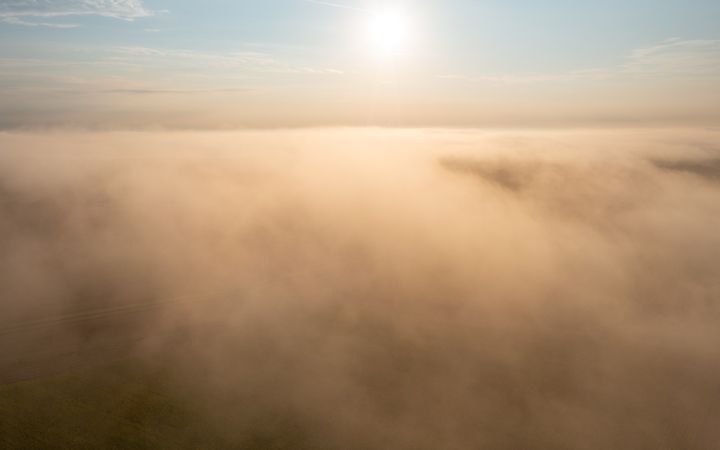 Sunrise foggy scenery at golden hour, drone aerial view