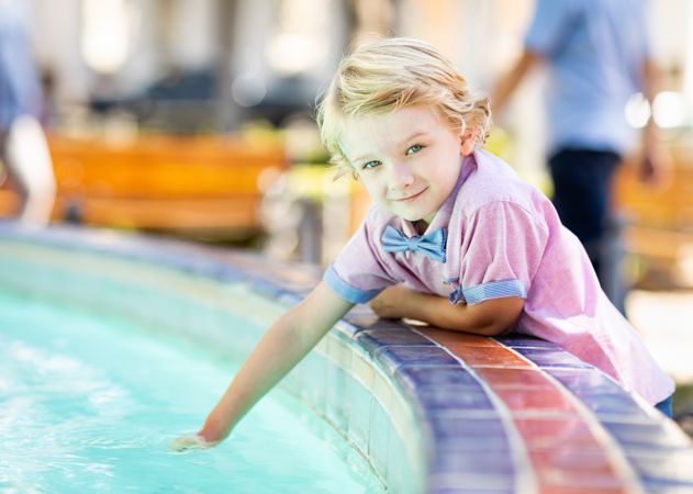 Cute Young Boy Enjoying The Fountain At The Park