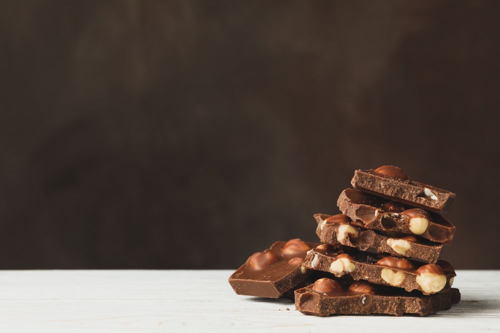 Tasty chocolate pieces on wooden table