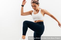 Woman exercises reaching her knee to her elbow bxLmXb
