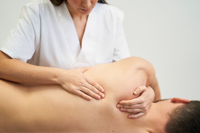 physiotherapist treating the patient's shoulder