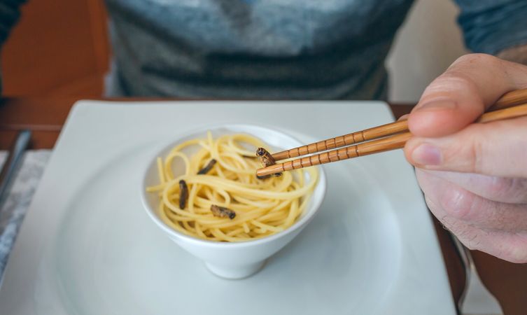 Man eating spaghetti and crickets