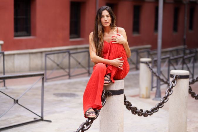 An Elegant Woman Wearing a Stunning Red Fashion Outfit Posing Gracefully Outdoors in Nature