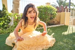 Cheerful girl sitting on lawn in yard