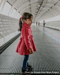 Girl in red coat standing in tunnel 4dkAd5