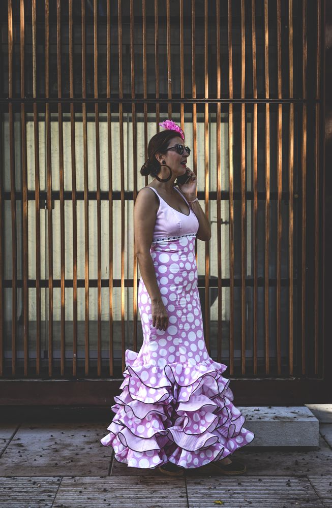 Erratic woman in flamenco dress talking on phone at street