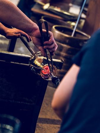 Anonymous masters making glass utensil in factory