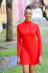 Smiling female in casual red dress walking outside