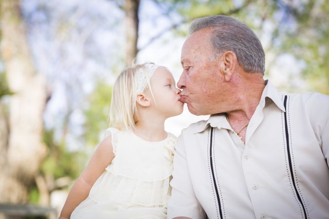 Grandfather and Granddaughter Kissing At The Park