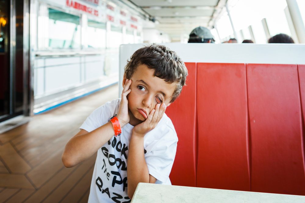 Boy making face with hands on seat