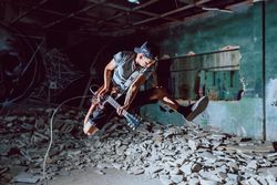 Musician playing electric guitar in abandoned place