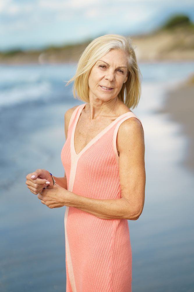 Vertical composition of calm mature woman standing near coast