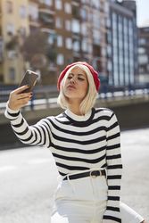 female in red beret taking selfie