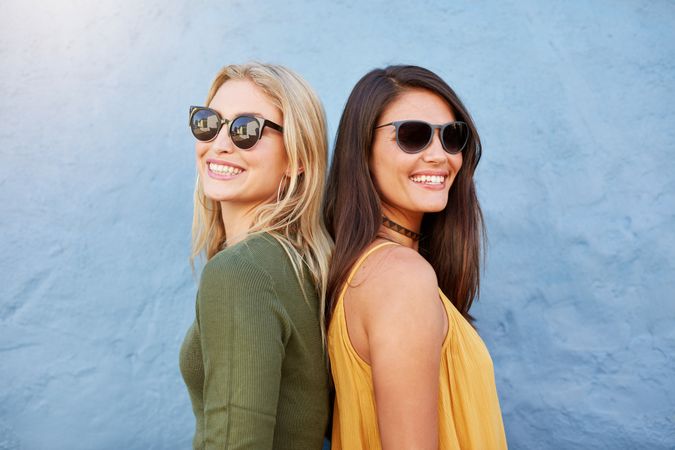 Shot of two young women smiling back to back