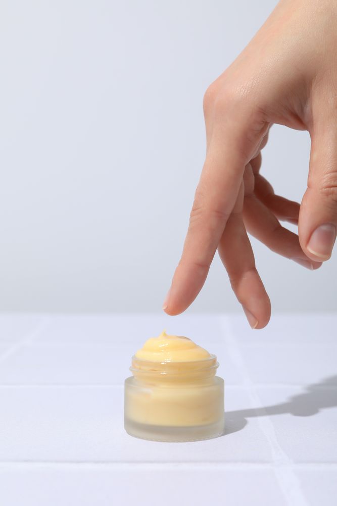 A jar of hand cream on a light background.