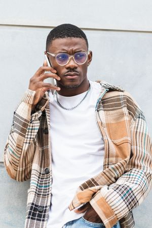 Stylish Black male using smartphone on street