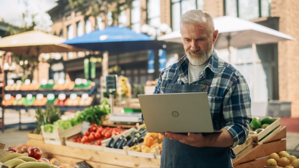 Successful Adult Male Farmer Working on a Laptop Computer
