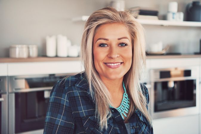 Portrait of blonde woman smiling in the kitchen