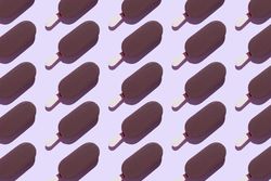 Multiple chocolate popsicles in diagonal rows on lavender background