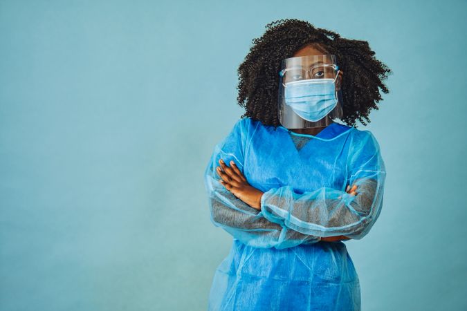 Black female medical professional in surgical PPE with her arms crossed