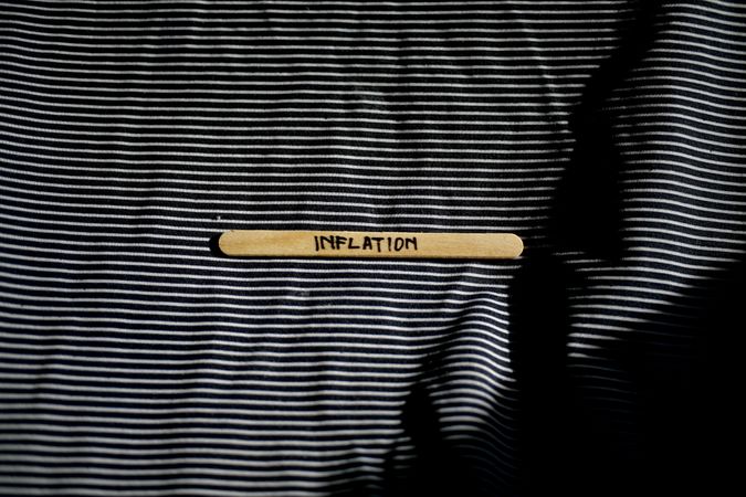 The word “inflation” written on wooden stick