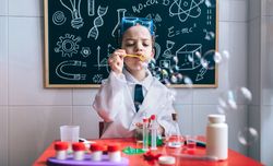 Kid doing soap bubbles in toy laboratory