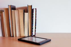 Vintage books next to an e-Book