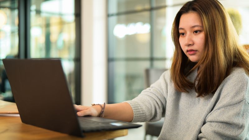 Asian woman using laptop on the desk, online learning, video chat.