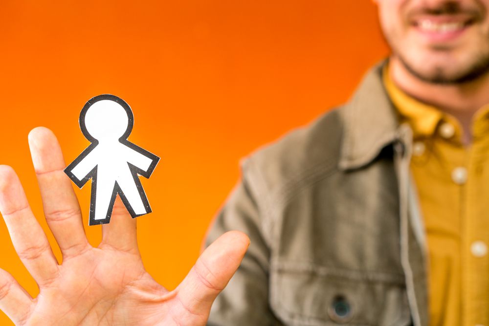 Smiling man holding funny paper toy