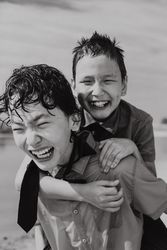 Happy boy in piggyback ride over back of brother