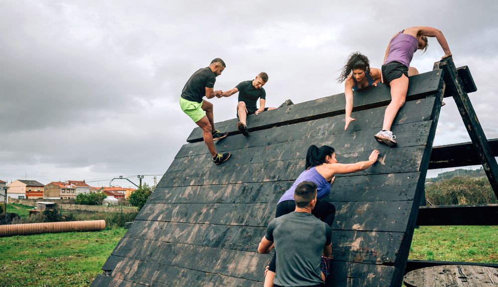 Participants in obstacle course climbing pyramid obstacle