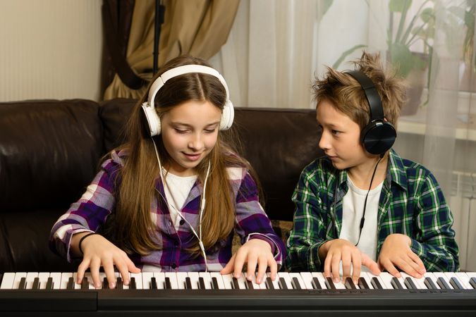 Focused Siblings' Piano Practice