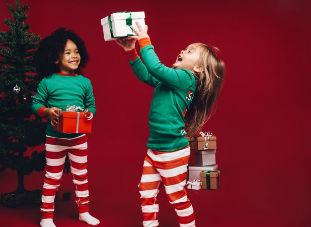 Little girls having fun playing with holiday gift boxes