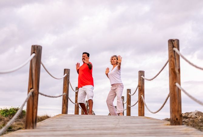 Couple practicing martial arts on lumber path