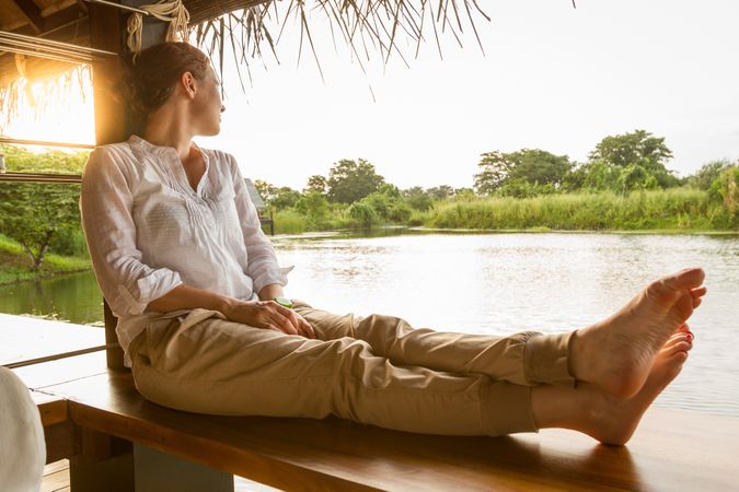 Barefoot woman looking at calm lake
