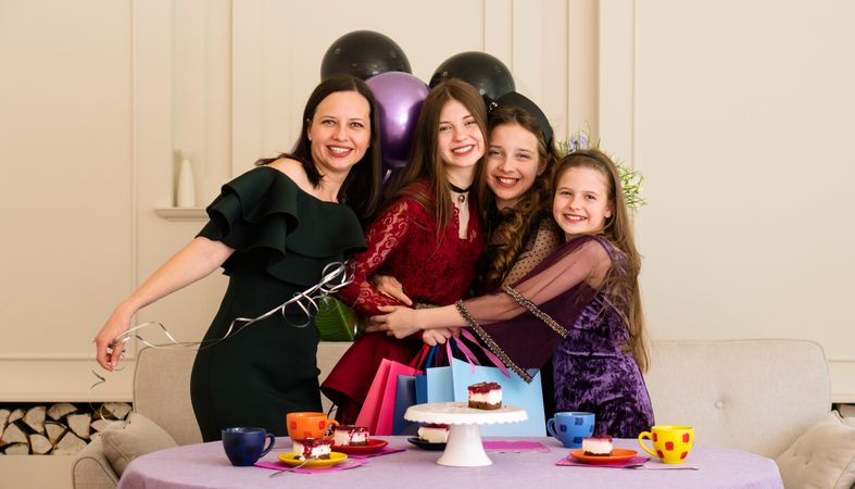 Teen with woman and two young girls. Birthday Party