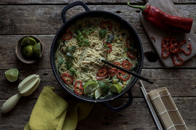 Green curry noodles in pot on table