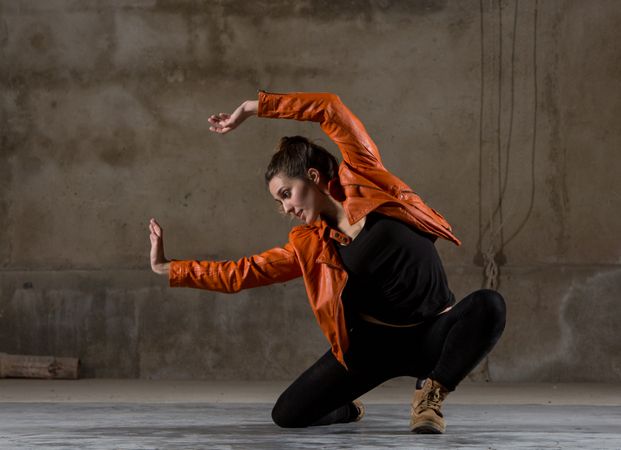 Young woman jumping in grey room