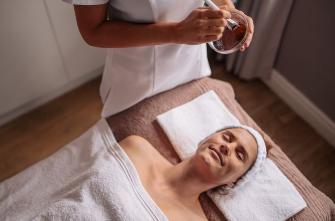 Female getting a facial mask treatment at beauty spa