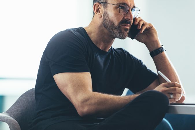 Man sitting at office and talking on mobile phone