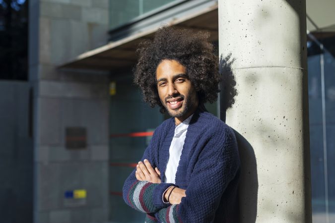 Smiling Black man standing with arms crossed on sunny day