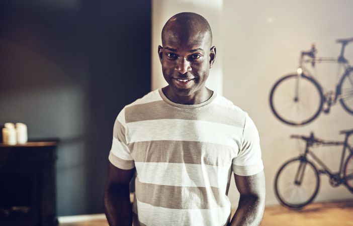 Portrait of smiling man in bright office with bicycles