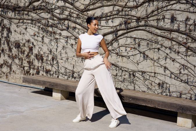 A dynamic dance pose against a vibrant wall backdrop, showcasing elegance and energy