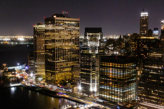 Aerial View of New York City at Night. Helicopter Shot of a Busy Highway Around Manhattan. Panoramic View with Traffic Around a Big City with Skyscrapers in the Background