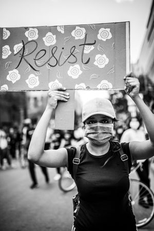 MONTREAL, QUEBEC, CANADA – June 7 2020- Woman in face mask holding "resist" sign